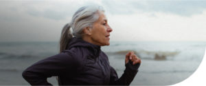 happy healthy woman who used patient financing services running on beach